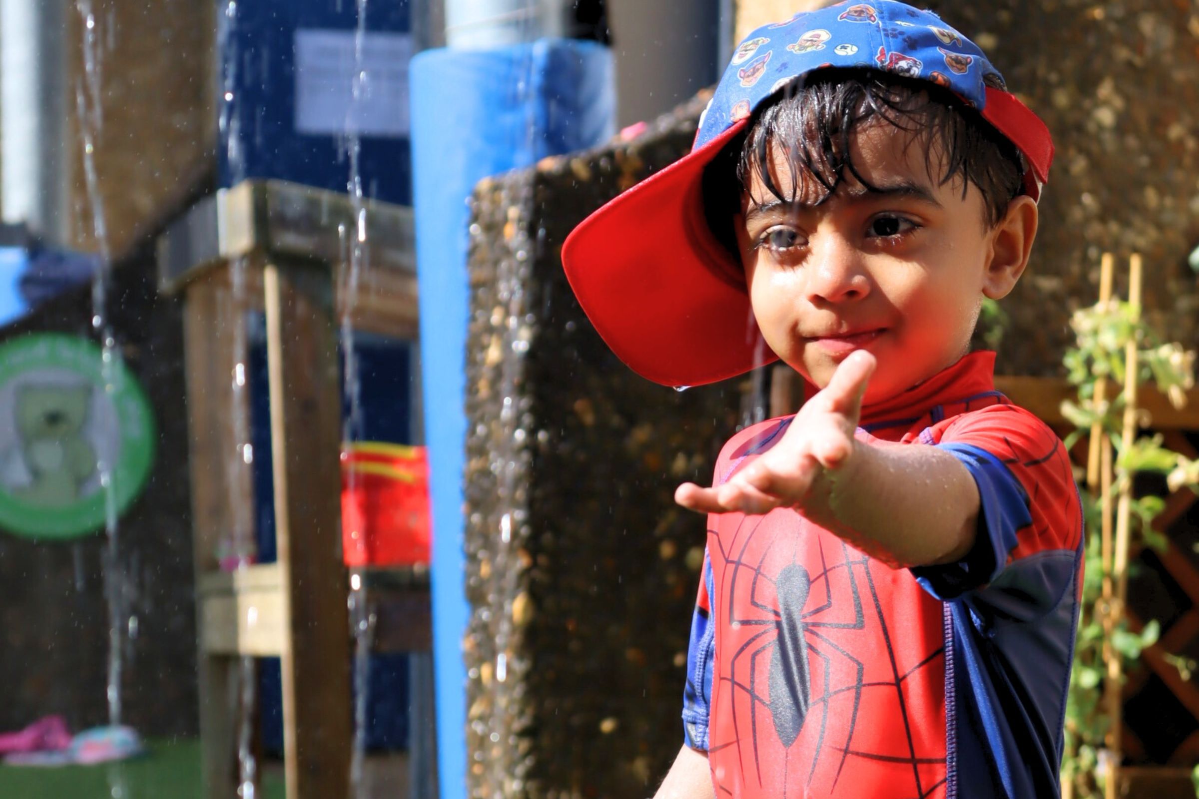 A Budding Learner enjoying the water jets in the nursery's garden during summer