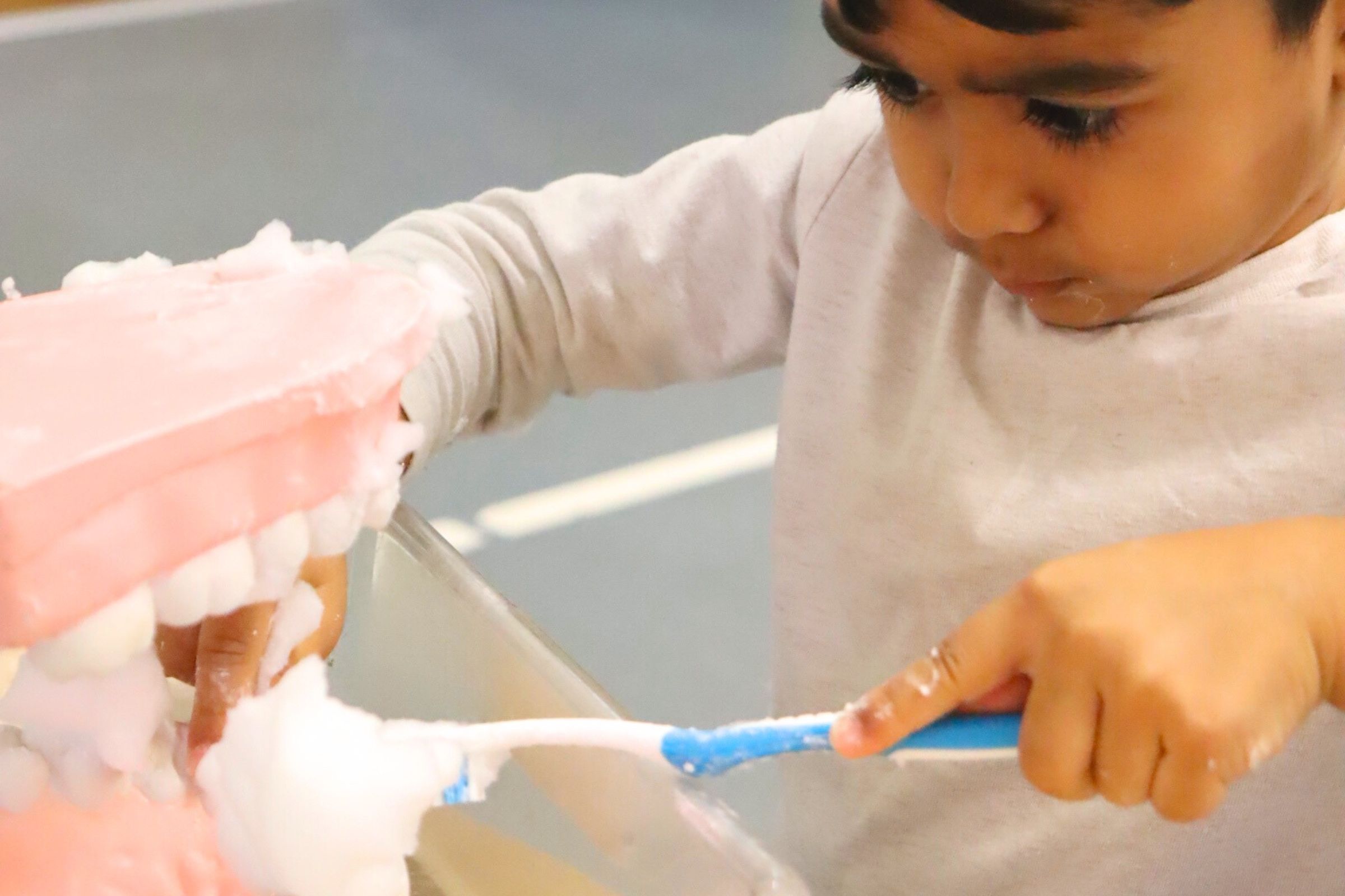 A budding learner participating in a tooth brushing activity during Oral Hygiene Week