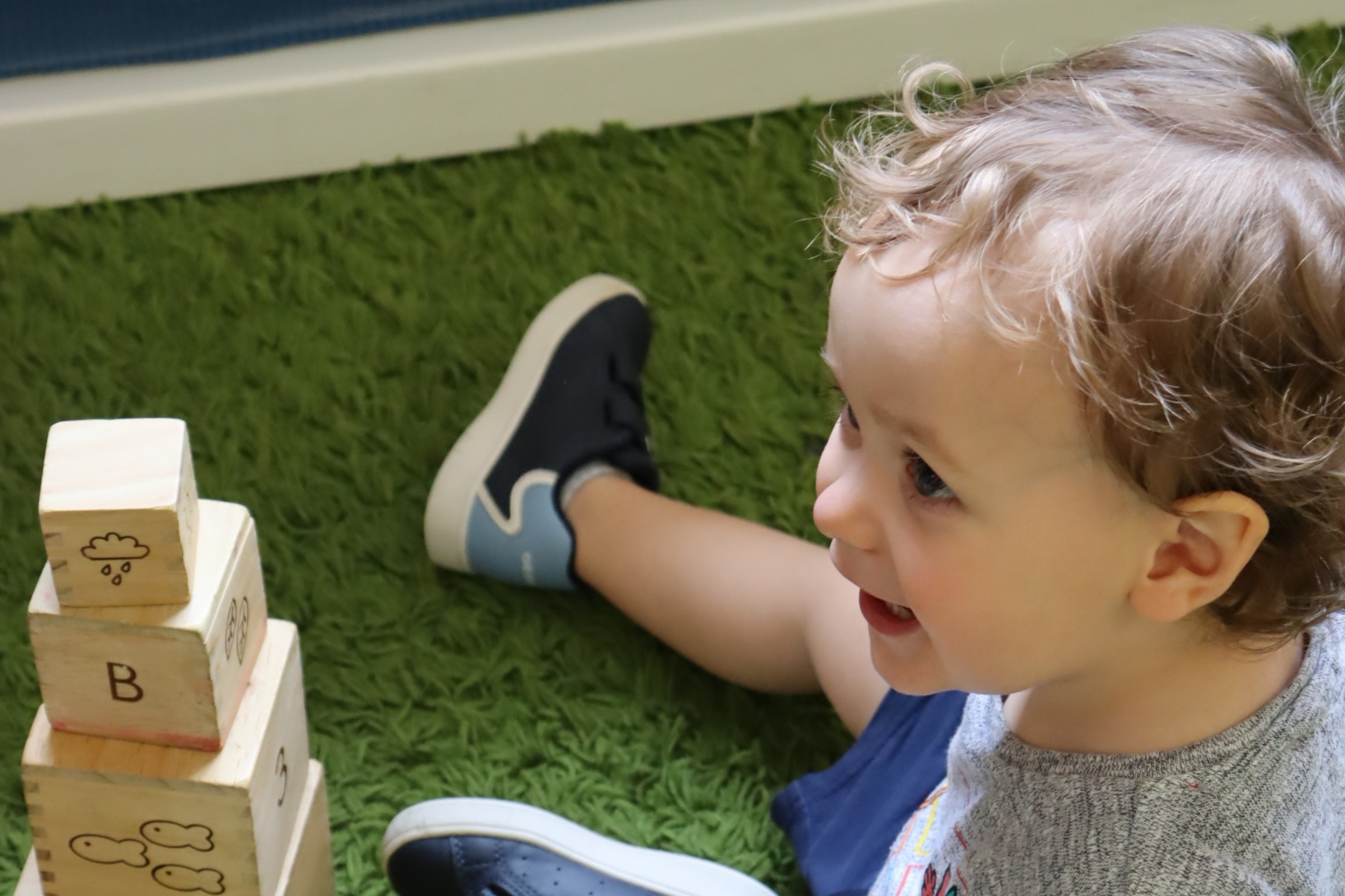 one of Budding Learners babies smiling to one of the Baby room's teachers