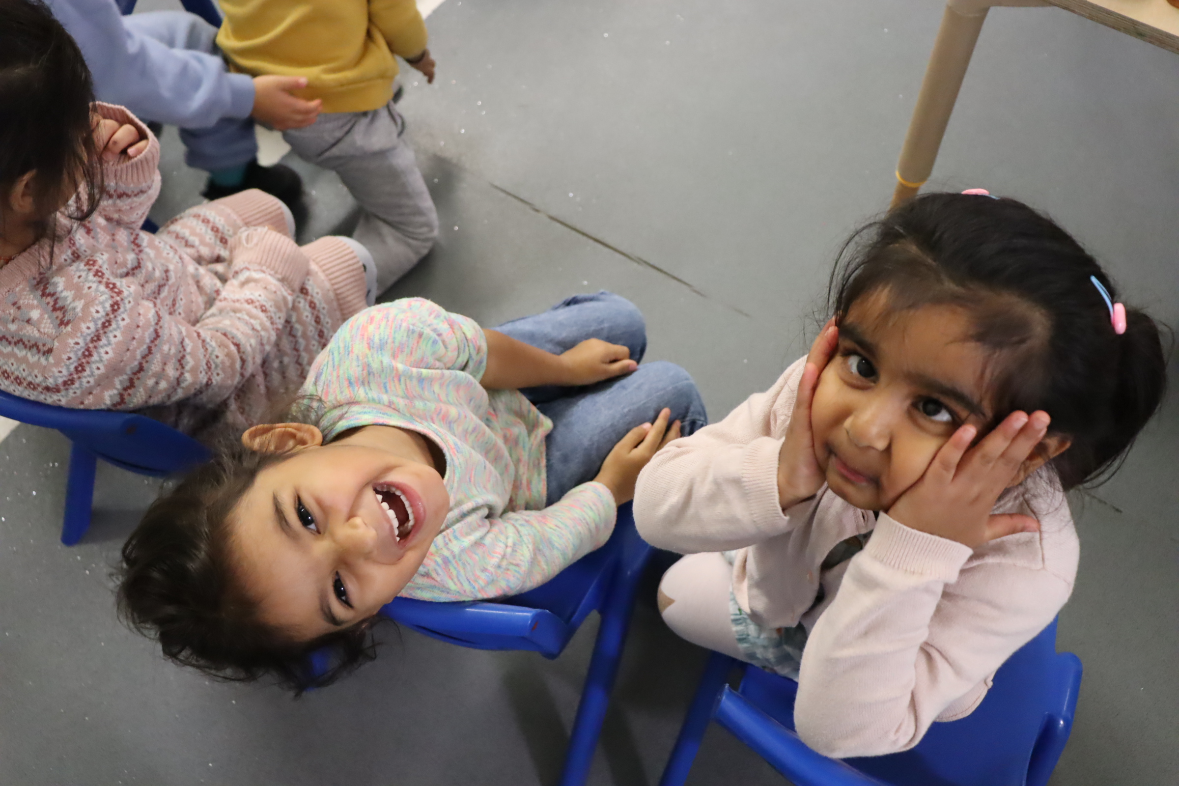 two adorable Budding Learners' preschoolers having fun while looking at the camera