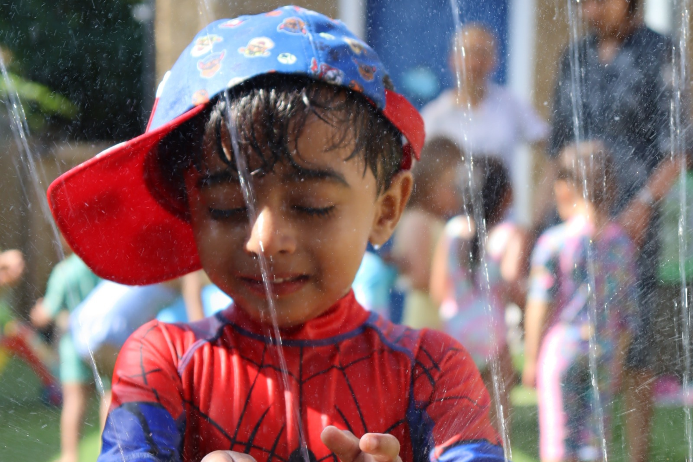 one of Budding Learners' toddlers having fun during summer with water in the nursery's garden