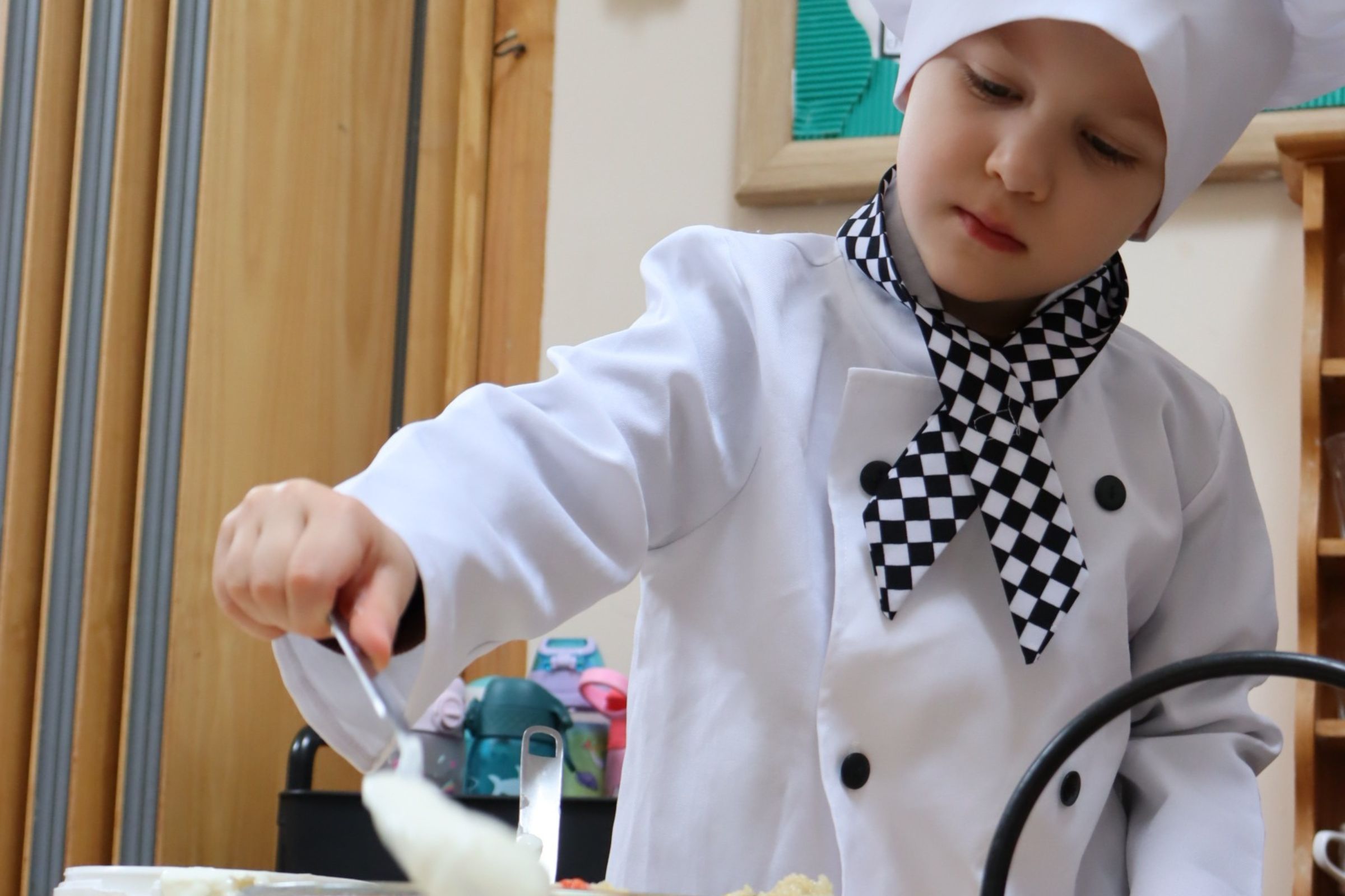 A Great Learner focusing on serving food to his peers during a weekly activity