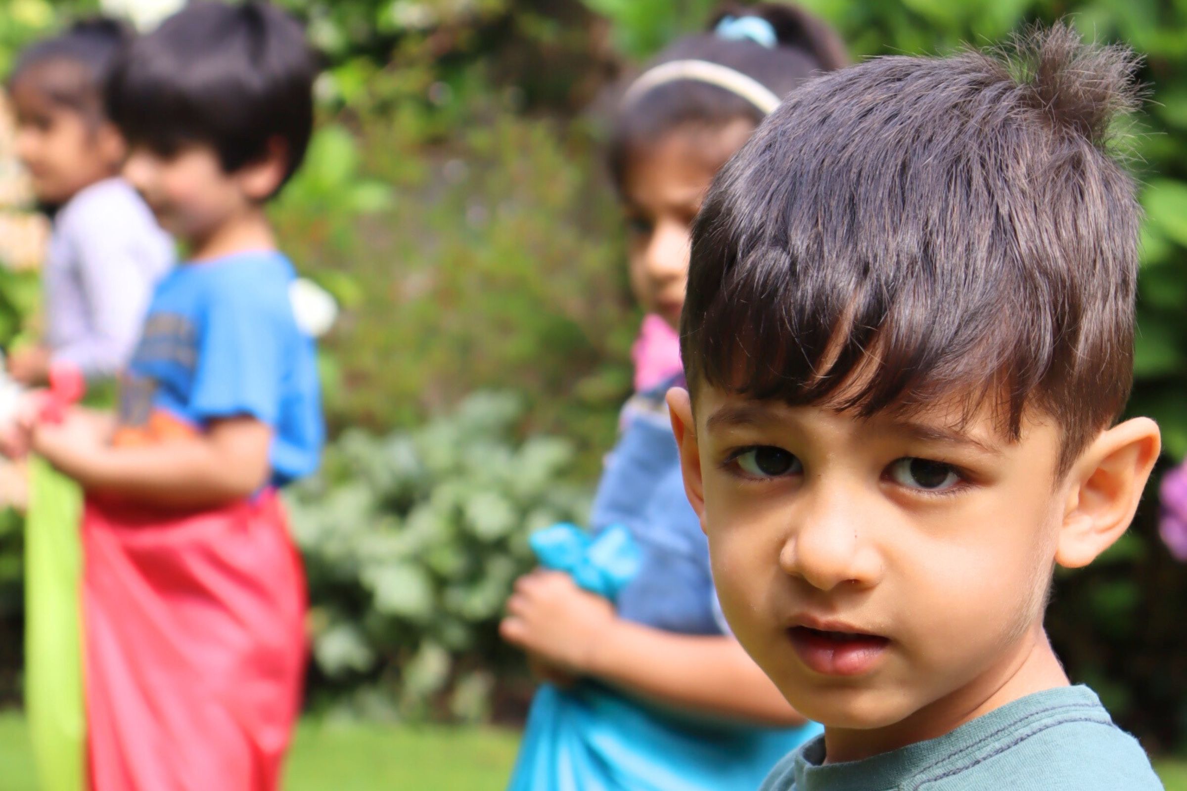 A preschooler concentrating on serving food to peers during a weekly activity